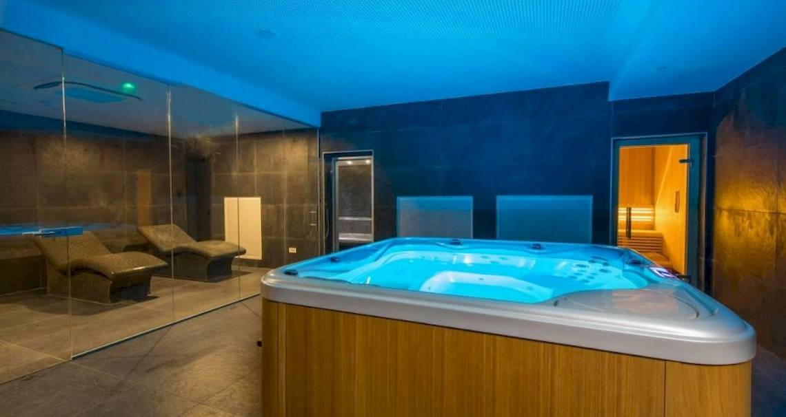 Jacuzzi-Raum im Osmine Slano Hotel mit blauen Lichtern und Lounge-Liegestühlen.