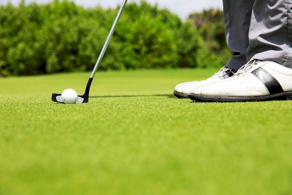 Golfer bereitet sich darauf vor, den Ball auf dem Golfplatz zu putten.