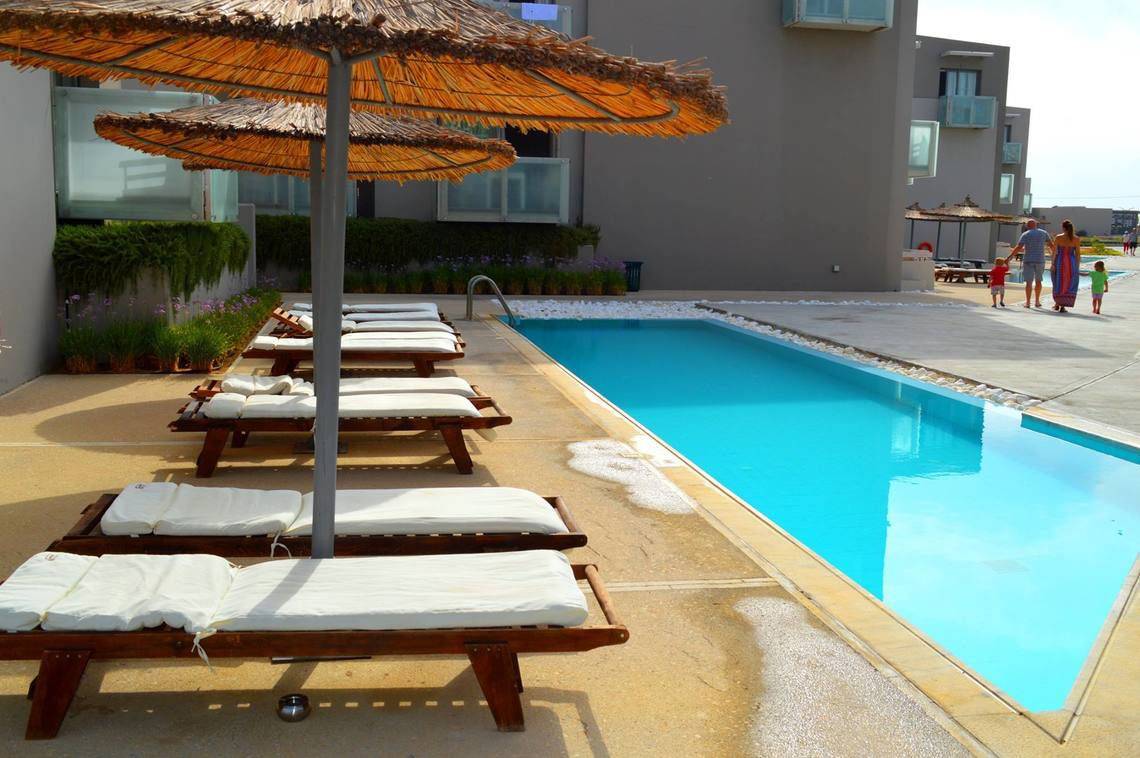 Akti Palace Hotel mit Pool und Liegestühlen, Familie im Hintergrund.
