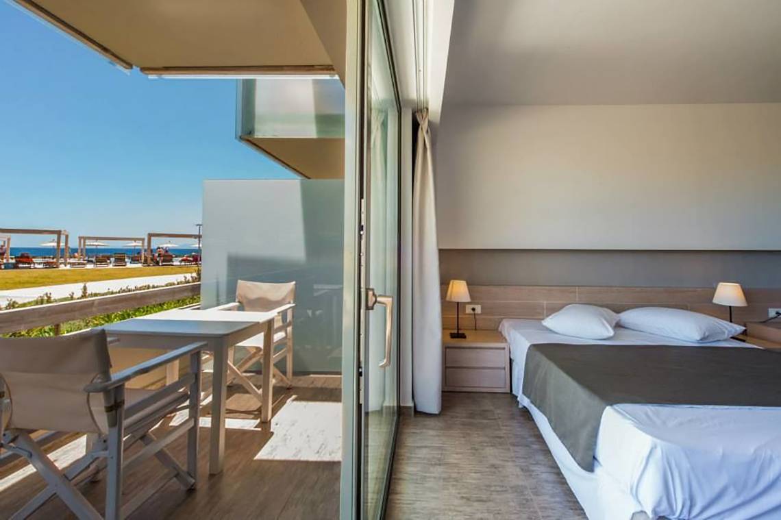 Akti Palace Hotel Zimmer mit Balkon und Meerblick, modernes Interieur, helle Farben, bequemes Bett und Tisch mit Stühlen