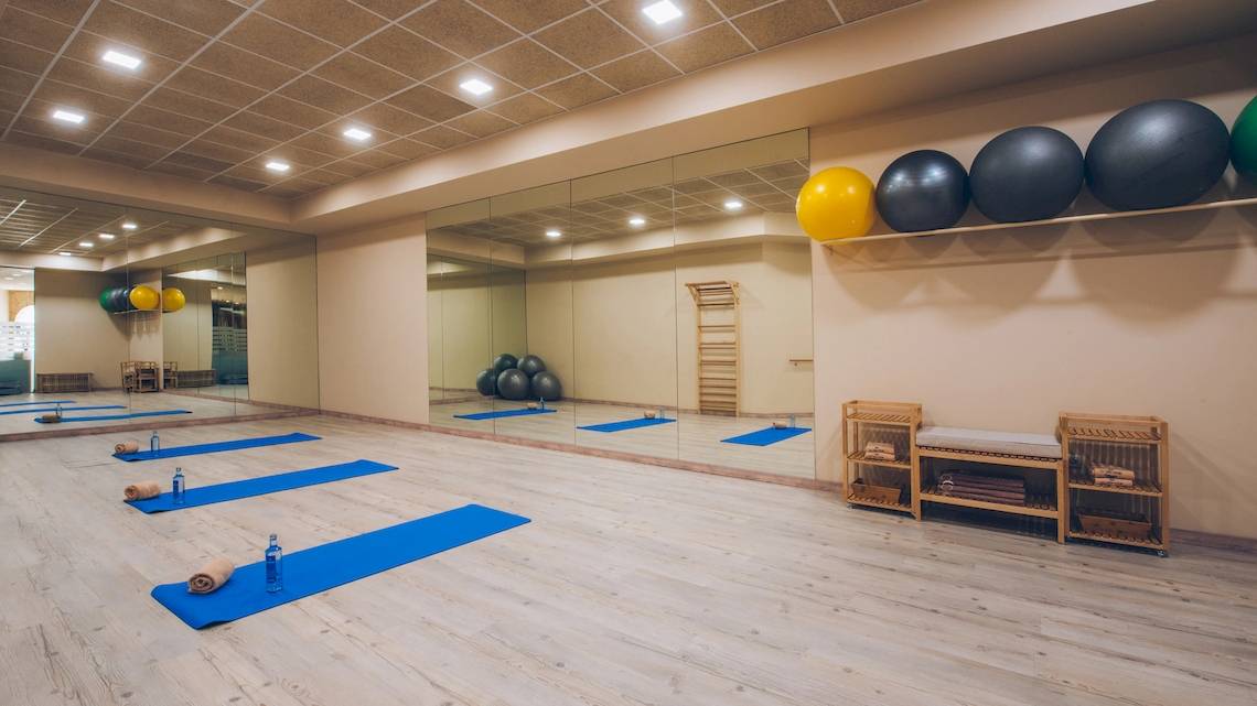 Fitnessraum im Iberostar Grand El Mirador mit Spiegeln, Yoga-Matten, und Fitnessbällen.