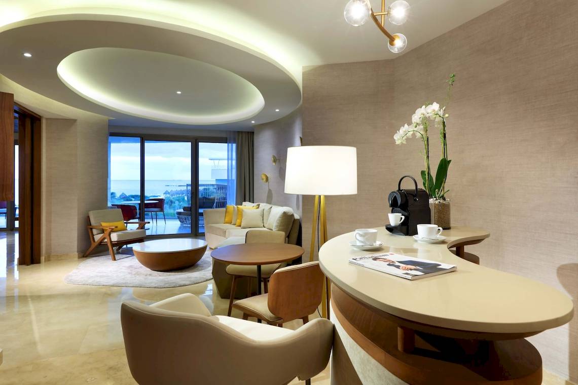Innenansicht des TRS Coral Hotels mit Wohnzimmermöbeln, Blick aufs Meer und moderner Einrichtung.