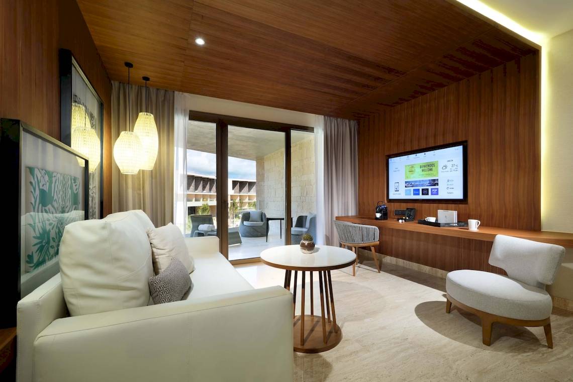 Wohnzimmerbereich des TRS Coral Hotels mit Sofa, Tisch, Fernseher und Deko.