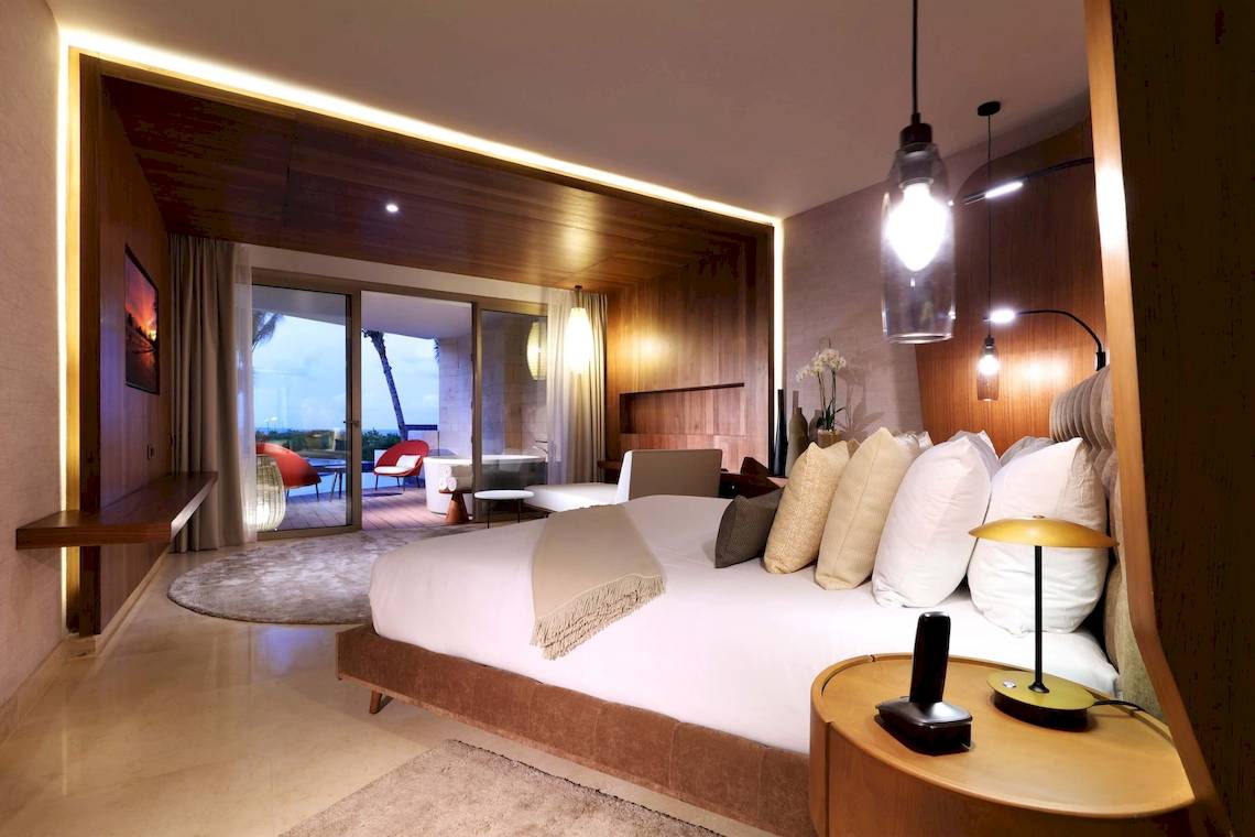Innenansicht eines Zimmers im TRS Coral Hotel mit großem Bett, Fenstern und Ausblick auf den Ozean.