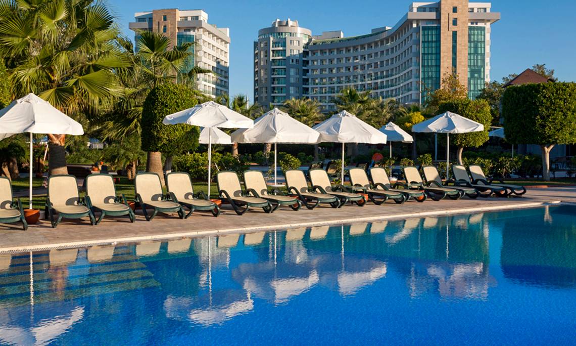Pool mit Liegestühlen und Sonnenschirmen im Sherwood Exclusive Lara Hotel