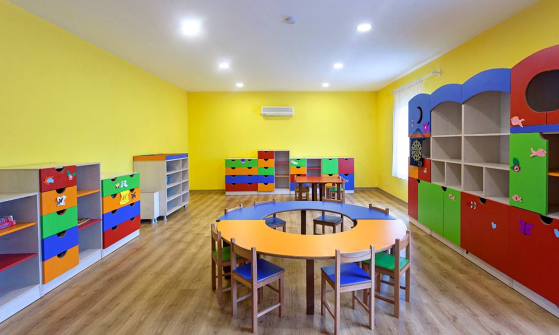 Kinderzimmer im Sherwood Exclusive Lara Hotel mit gelben Wänden und bunten Möbeln.