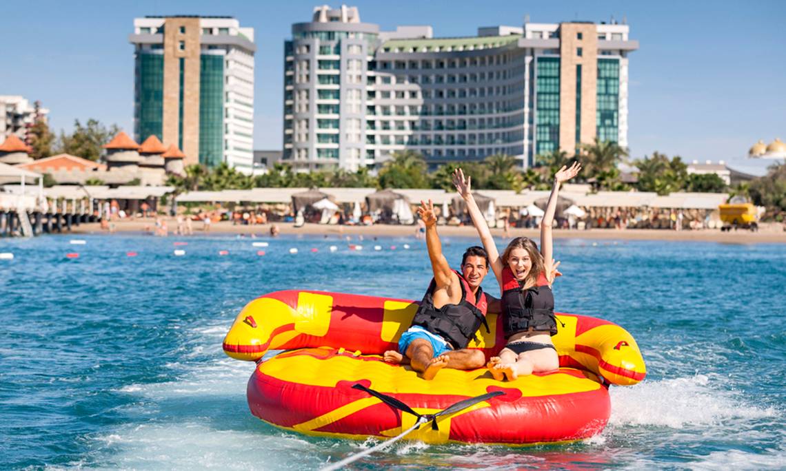 Paar auf einem aufblasbaren Boot vor dem Sherwood Exclusive Lara Hotel