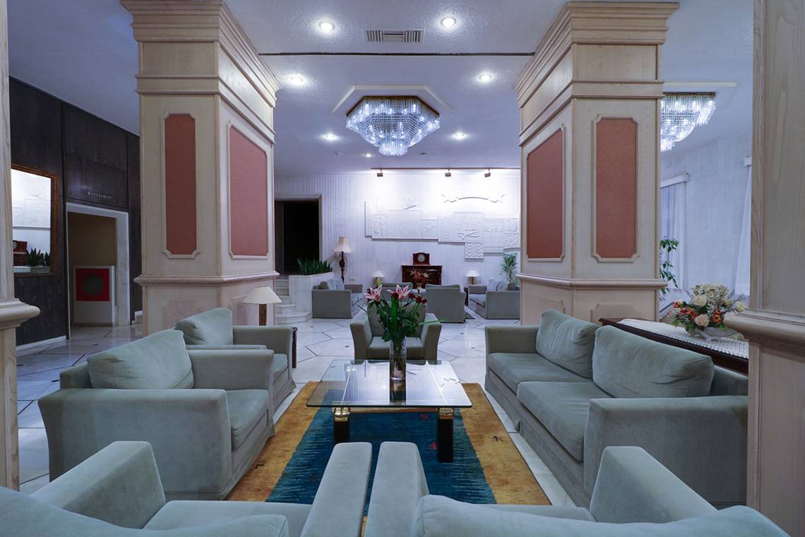 Empfangsbereich des Creta Star Hotels mit Sofas, Tischen und einem Blumenarrangement.