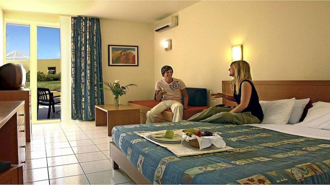 Zwei Personen sitzen in einem Hotelzimmer des Royal & Imperial Belvedere, mit Blick auf den Garten.