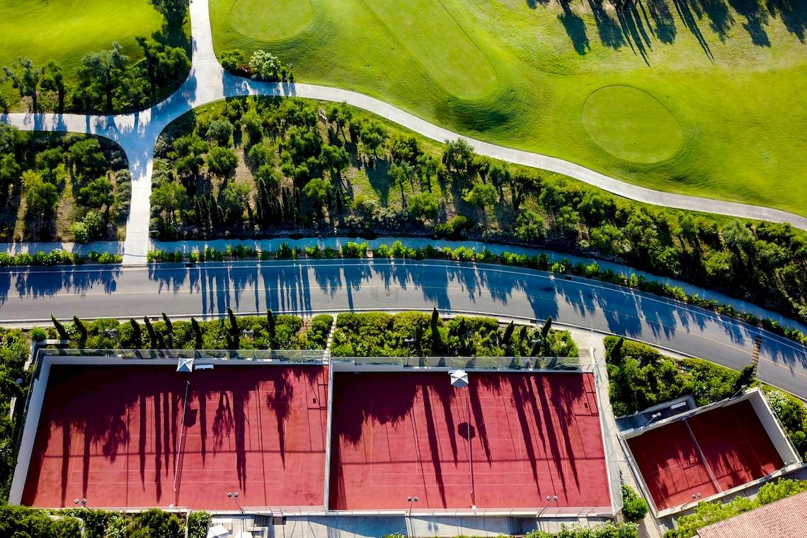 Aussenansicht des Westin Resorts Costa Navarino mit Tennisplätzen und einem Golfplatz