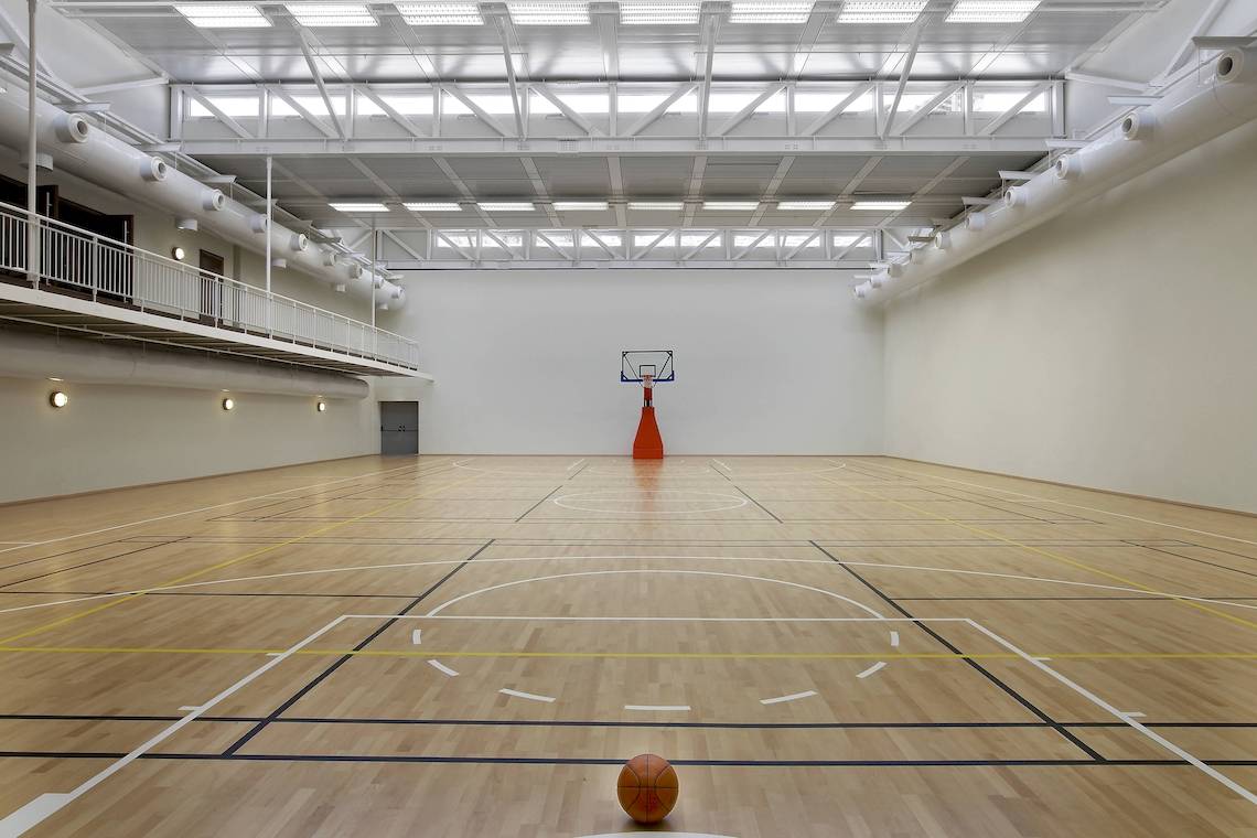 Basketballhalle im The Westin Resort, Costa Navarino, leer mit einem Ball auf dem Boden.