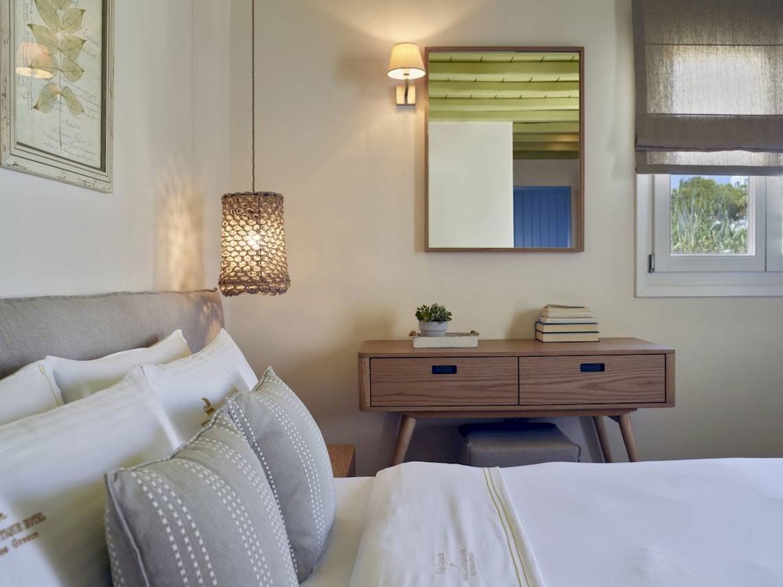 Hotelzimmer im Vencia Boutique Hotel mit Bett, Nachttisch und Wanddekoration.