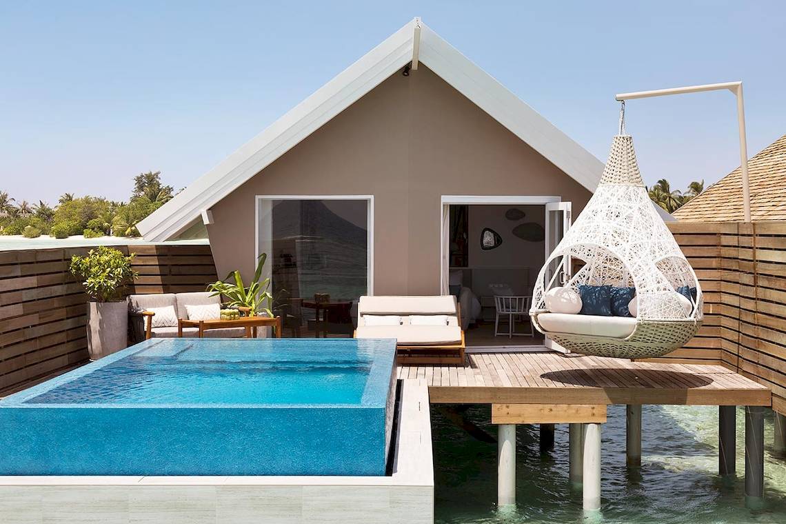 Außenbereich des LUX South Ari Atoll Wasserbungalows mit Swimmingpool und Hängesessel