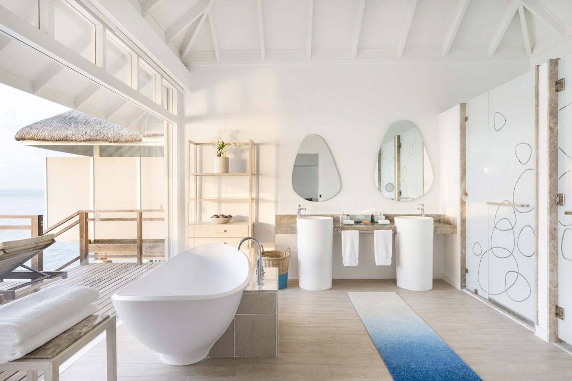 Ein Badezimmer im LUX South Ari Atoll Hotel mit großer Badewanne und zwei Waschbecken.