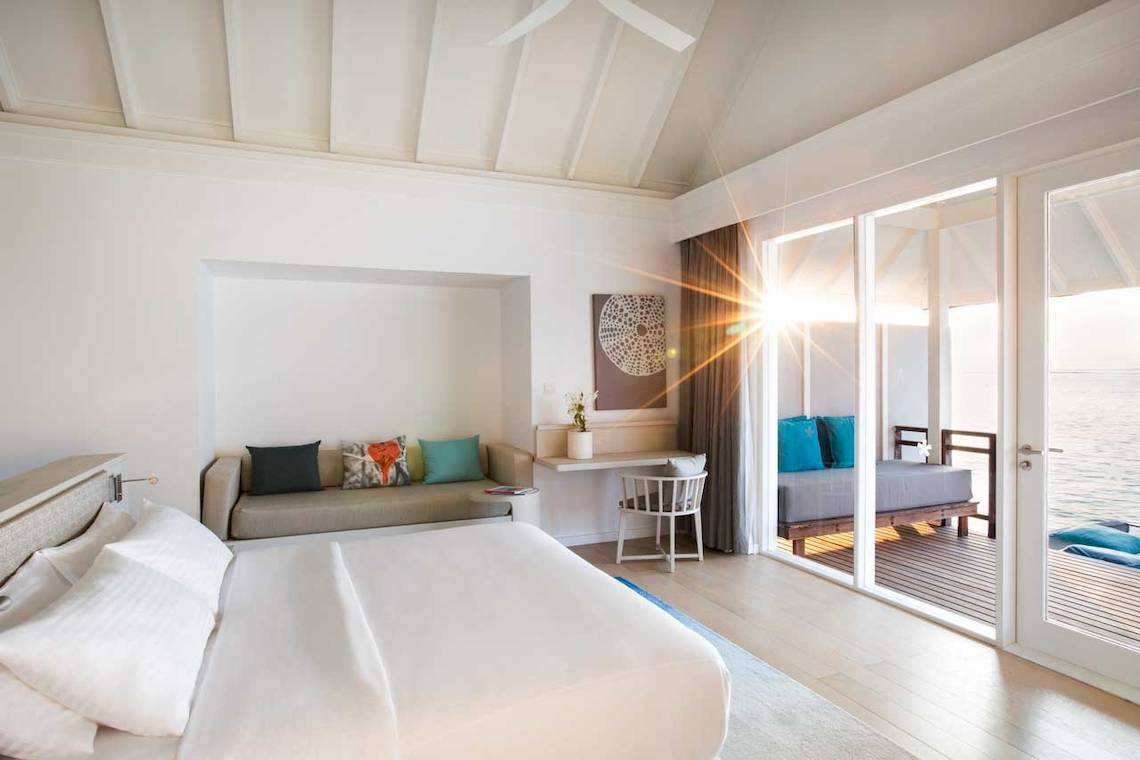 Luxuriöses Zimmer im LUX South Ari Atoll Hotel mit Blick auf das Meer und Sonnenlicht.
