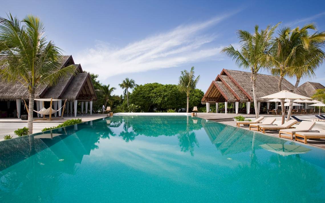 Außenpool mit Sonnenliegen und Sonnenschirmen im LUX South Ari Atoll