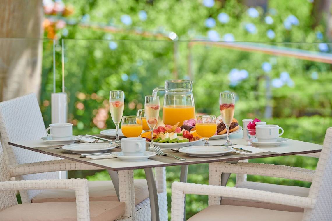 Frühstückstisch im Freien im Hipotels Said Hotel mit Getränken und Speisen.