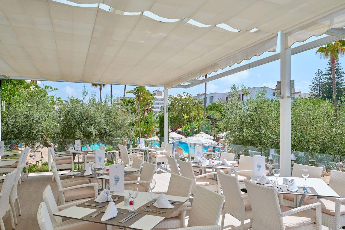 Restaurantterrasse des Hipotels Said mit Tischen, Stühlen und einem Blick auf den Pool.