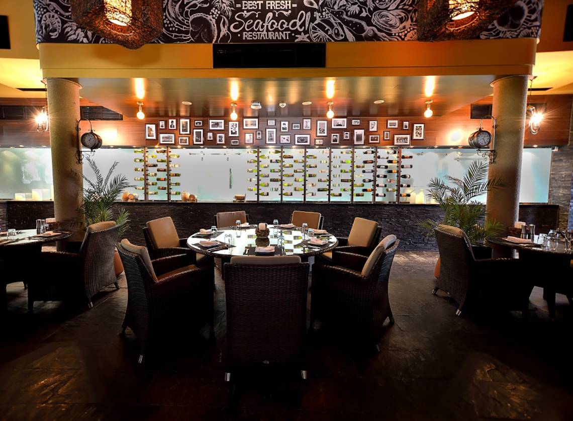 Innenbereich des Best Fresh Seafood Restaurants mit runden Tisch und Flaschendisplay.