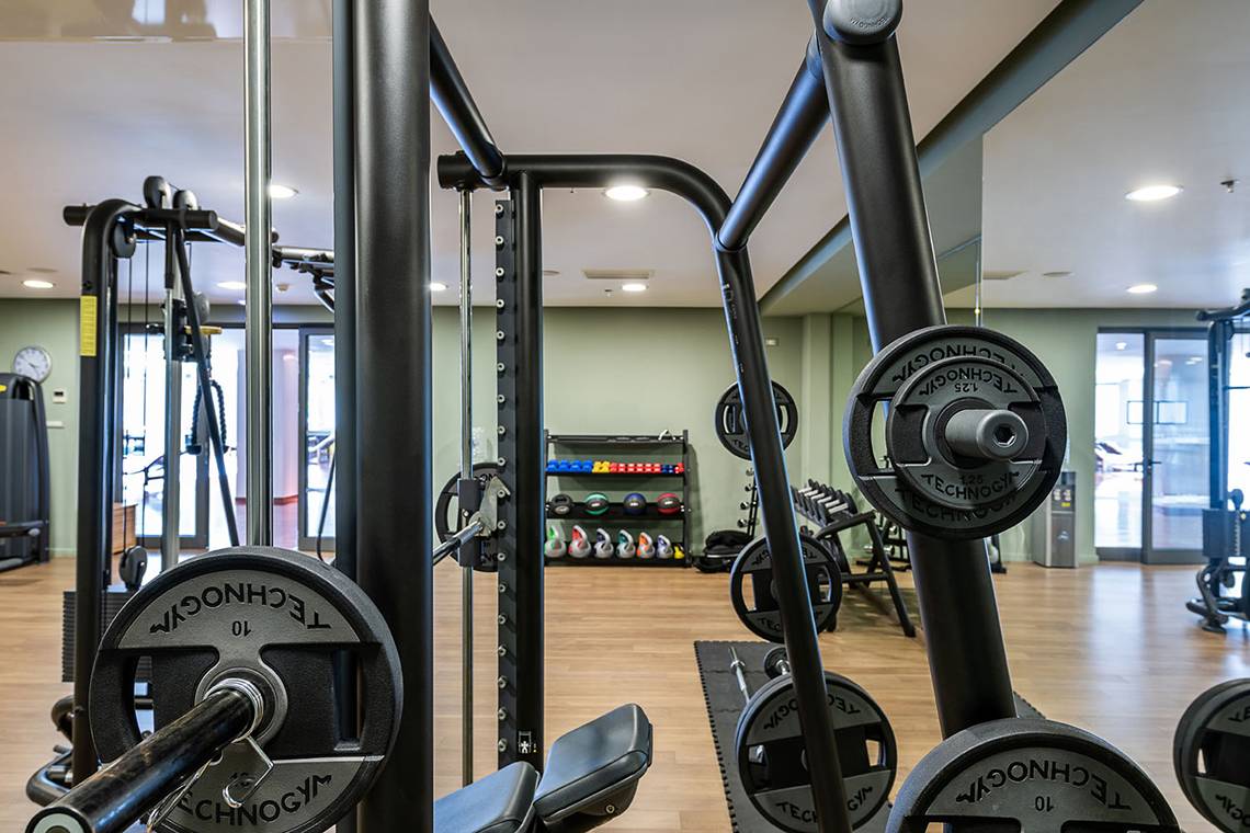 Fitnessstudio im Avra Imperial Hotel mit Trainingsgeräten und Gewichten.