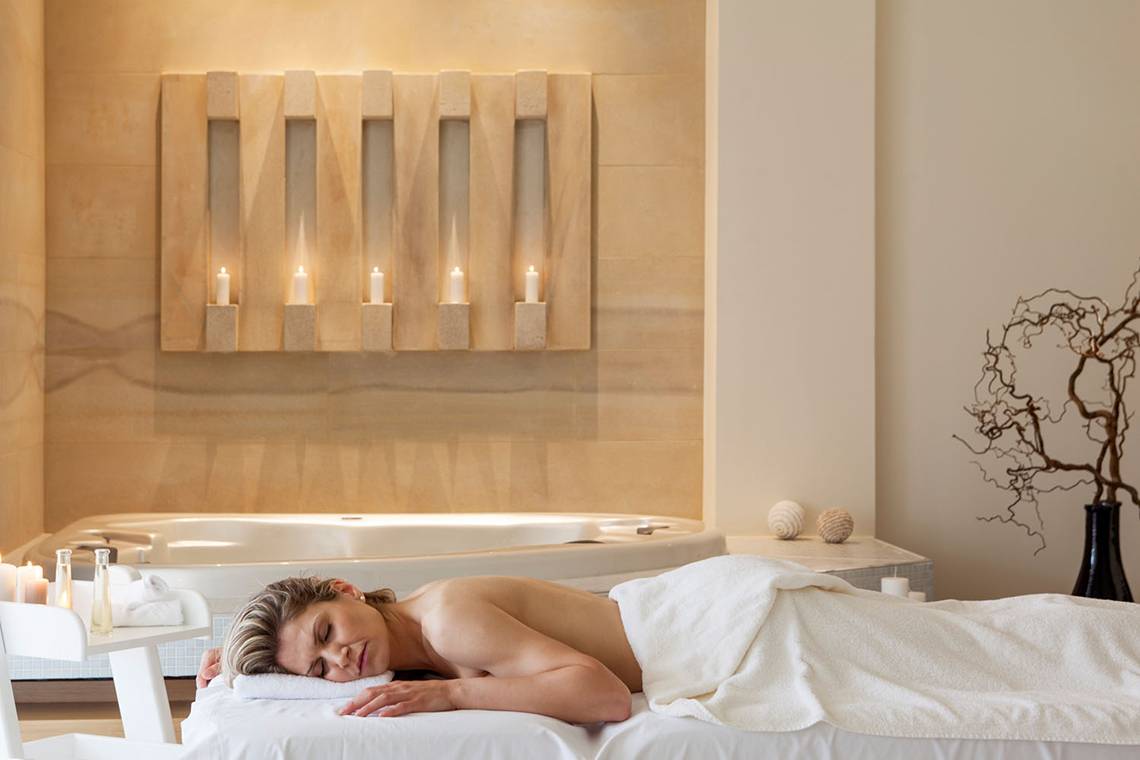 Eine Frau schläft im Spa-Bereich des Avra Imperial Hotels, eingewickelt in ein weißes Handtuch.