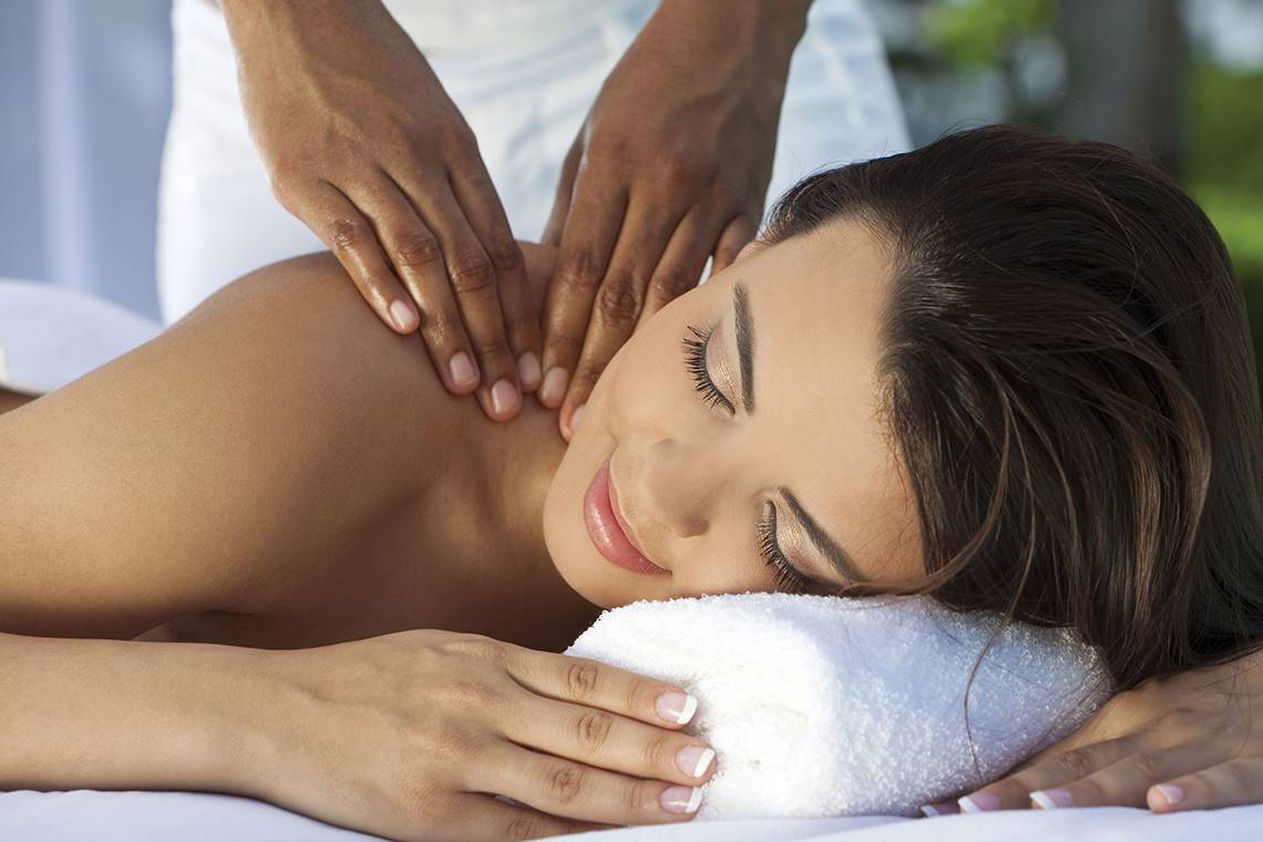 Eine Frau genießt eine Massage im Wellnessbereich des Hotels.