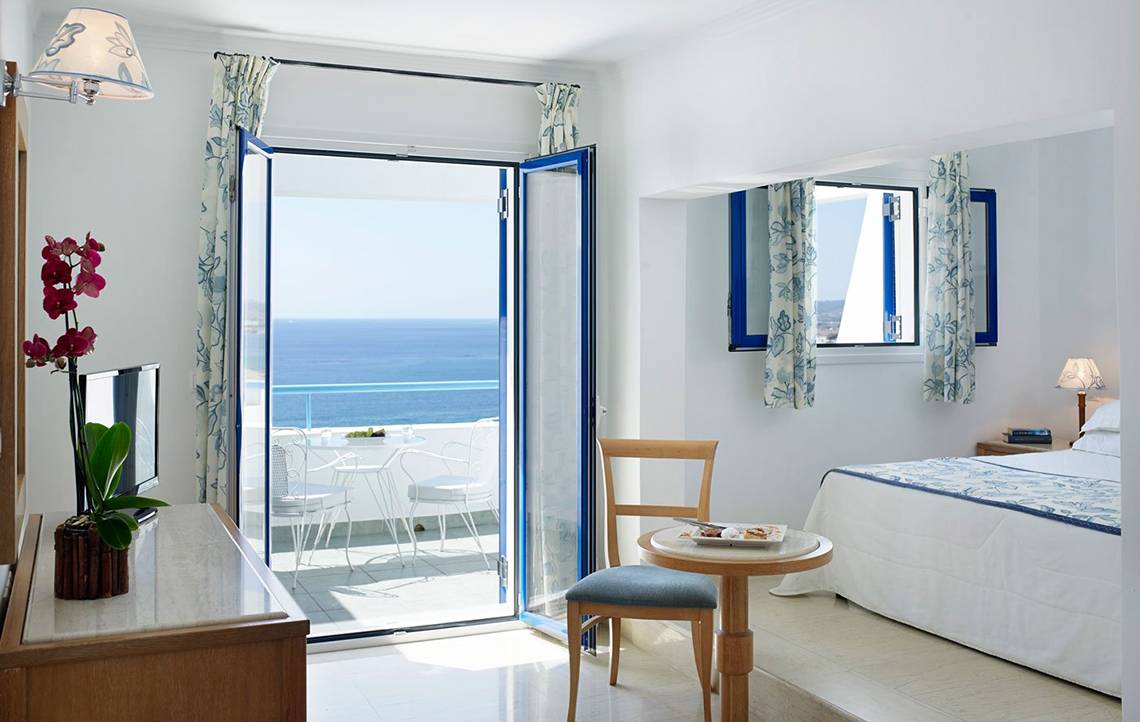 Mitsis Norida Beach Hotel Zimmer mit Meerblick, Balkon und offenem Fenster.