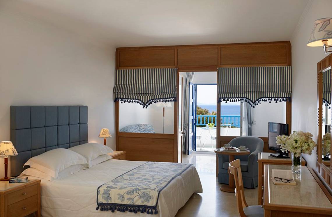 Schlafzimmer im Mitsis Norida Beach Hotel mit Blick auf das Meer und Balkon.