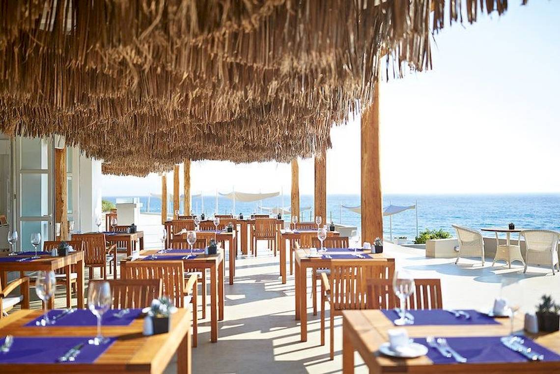 Außenbereich des Restaurants im Grecotel La Riviera & Aqua Park mit Blick auf das Meer.