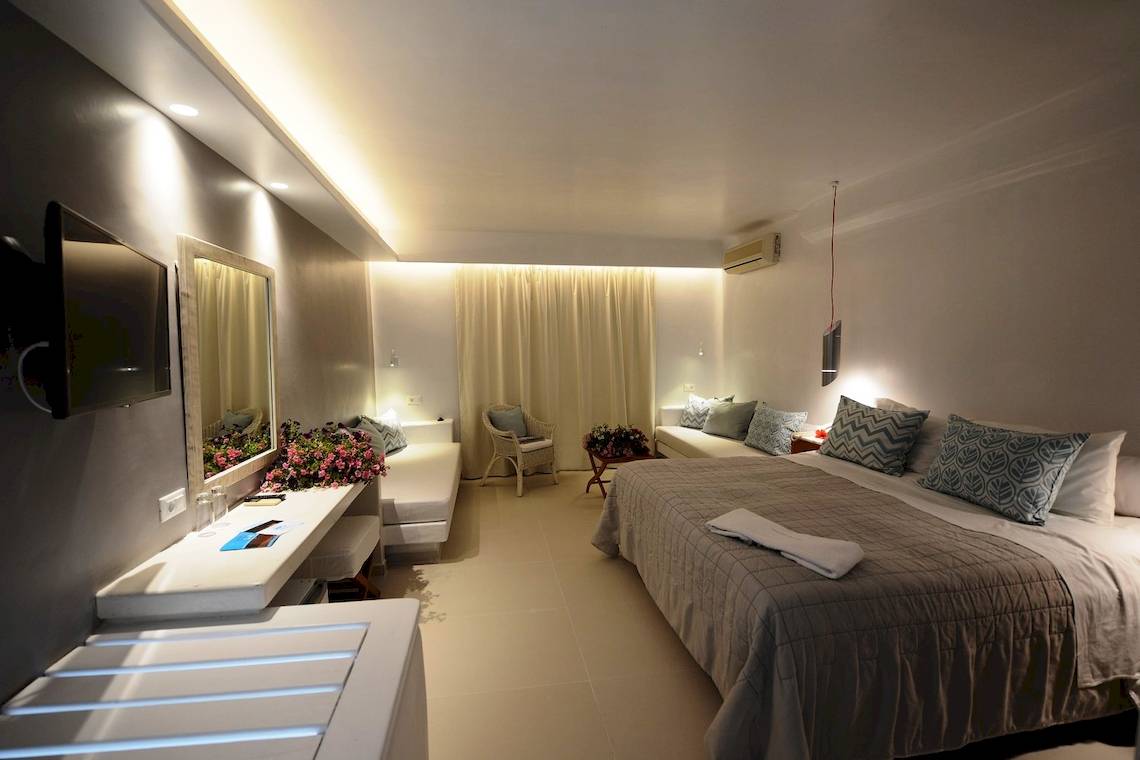 Das Schlafzimmer im MykonosView Hotel mit einem großen Bett, Dekor und Möbeln.