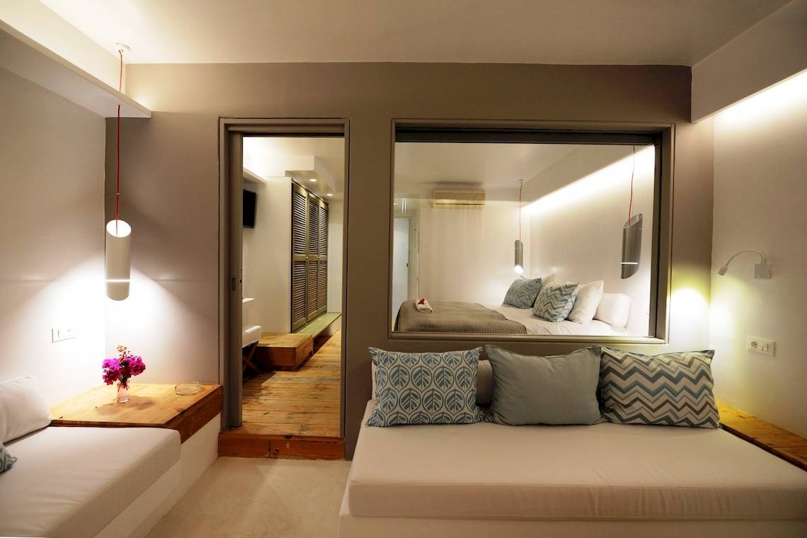 Schlafzimmer des MykonosView Hotels mit Bett, Spiegel und Dekor.