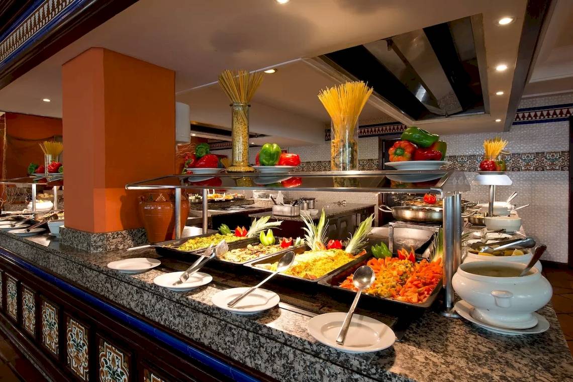 Buffet-Tisch im Bluebay Banus Hotel mit verschiedenen Gerichten und Zutaten.