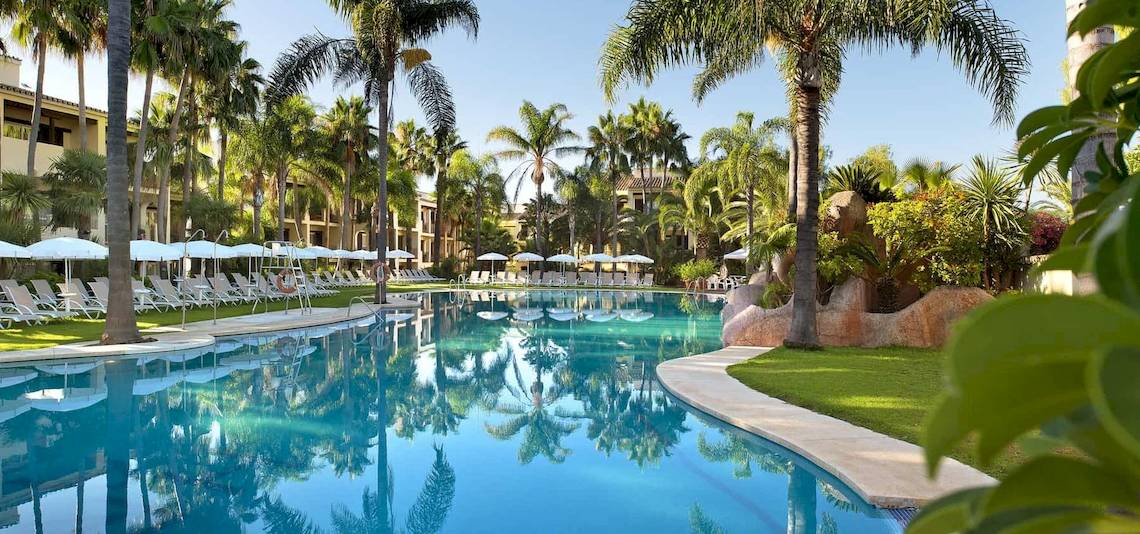 Außenpool des Bluebay Banus Hotels mit vielen Sonnenliegen und Palmen