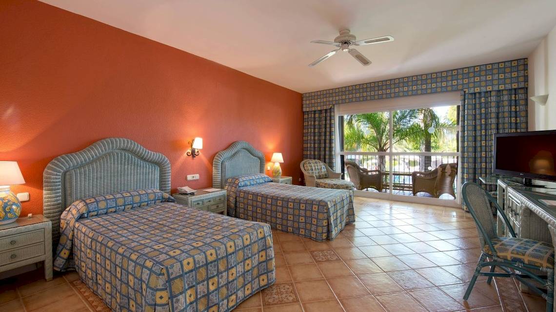 Doppelzimmer im Bluebay Banus Hotel mit zwei Betten, Fernseher und Balkon