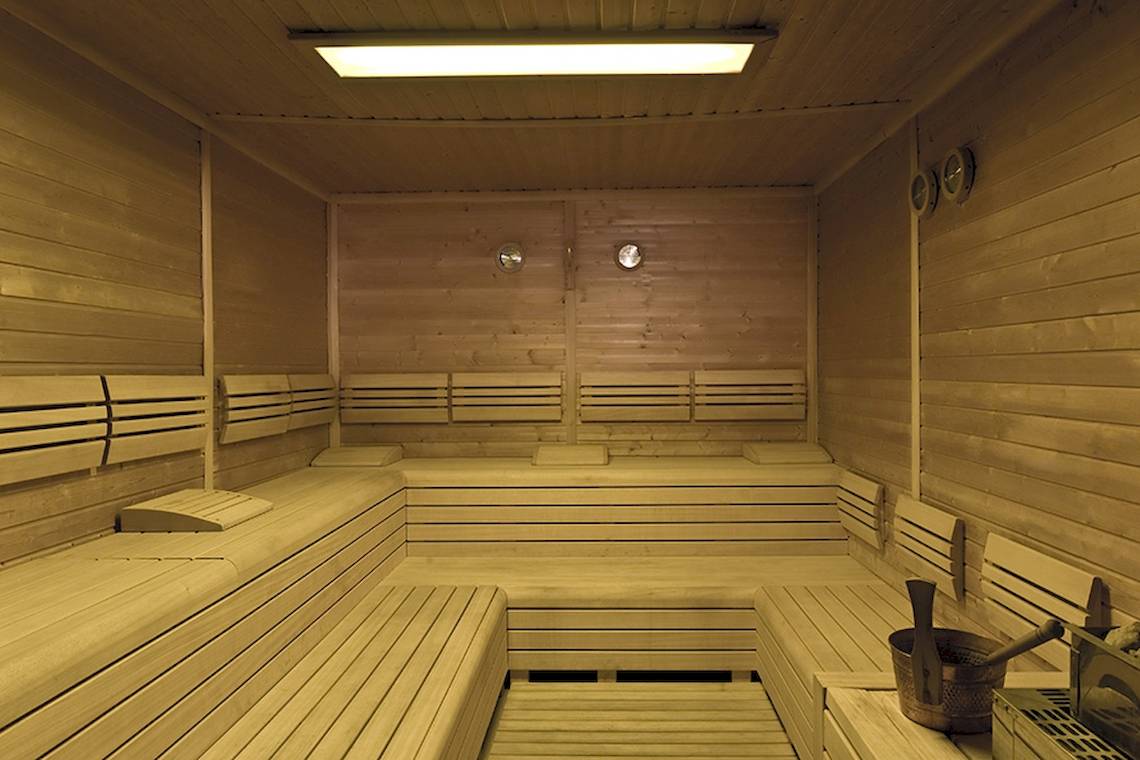 Holzsauna im Rixos Premium Dubrovnik mit gepolsterten Bänken und Metalleimer