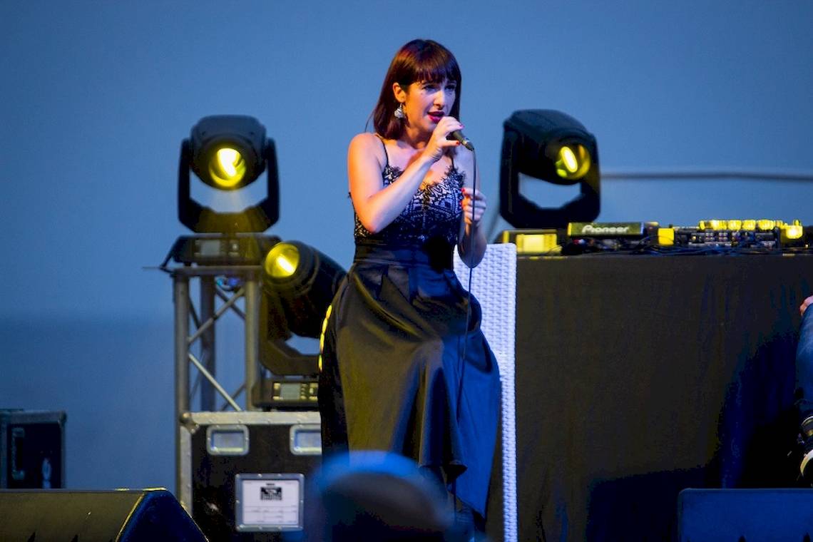 Eine Frau steht auf der Bühne und singt in ein Mikrofon