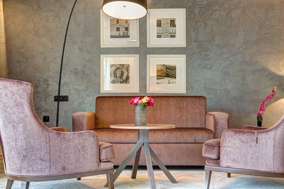 Loungebereich im Rixos Premium Dubrovnik mit einem Sofa, einem Tisch und zwei Sesseln.