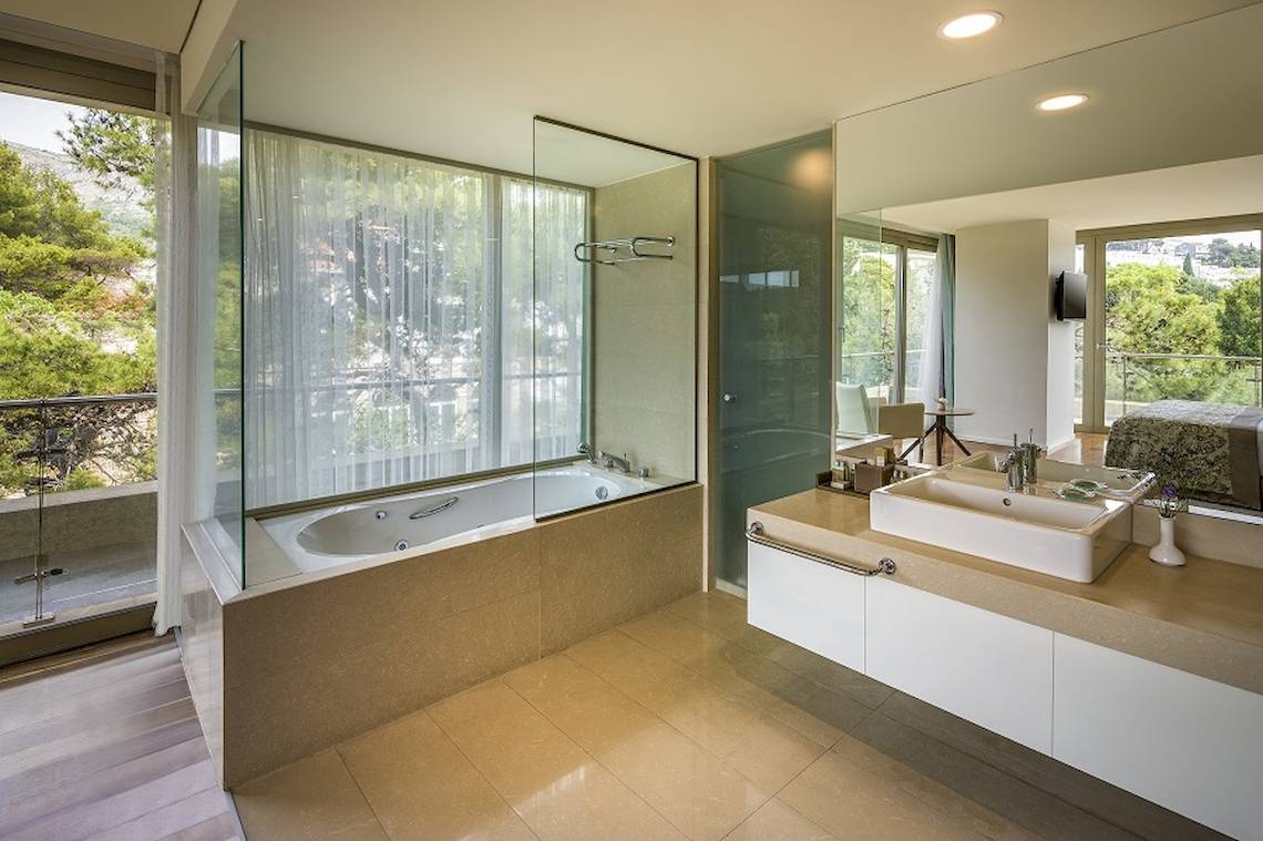 Luxusbadezimmer mit Badewanne, Dusche und Aussicht auf die Stadt.