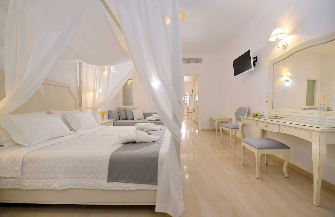 Schlafzimmer im Kamari Hotel mit weißem Himmelbett, Bettwäsche und Dekor