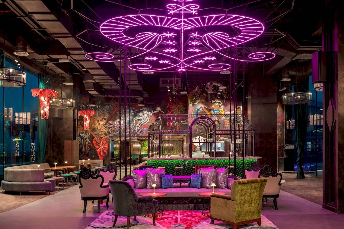 Loungebereich des W Dubai - The Palm Hotels mit lila Beleuchtung und modernen Möbeln.