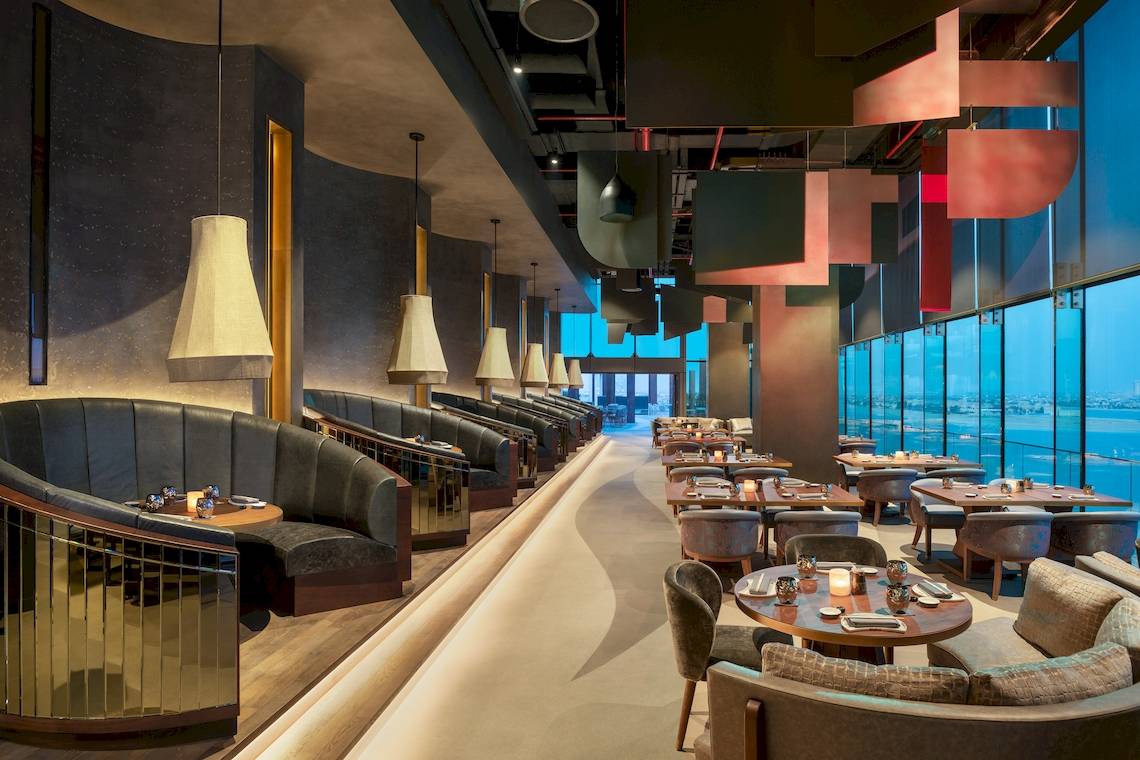 Innenansicht des Restaurants W Dubai - The Palm mit modernen Möbeln und Meeresblick.