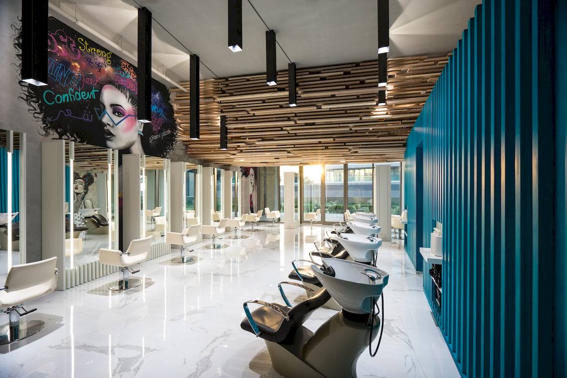 Innenansicht des Friseursalons im W Dubai - The Palm mit weißen Stühlen und blauen Wänden.