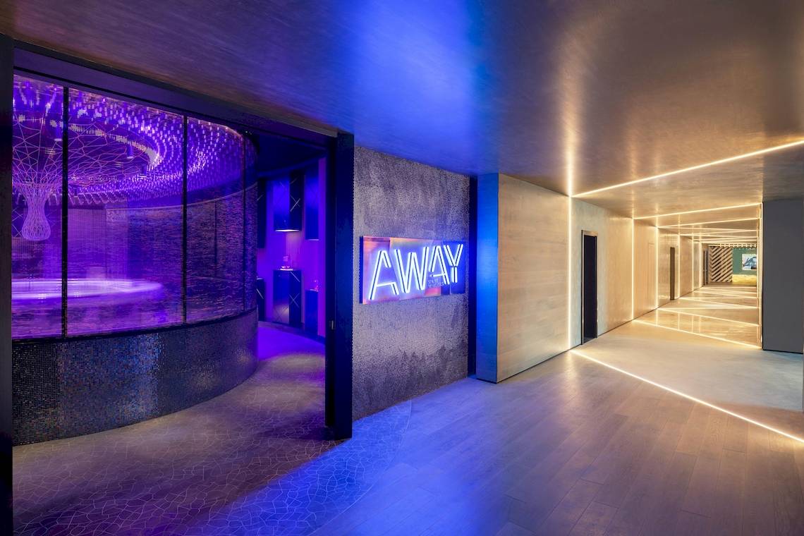 Lobby des W Dubai - The Palm mit blauer Beleuchtung und einem Schild mit der Aufschrift AWAY.