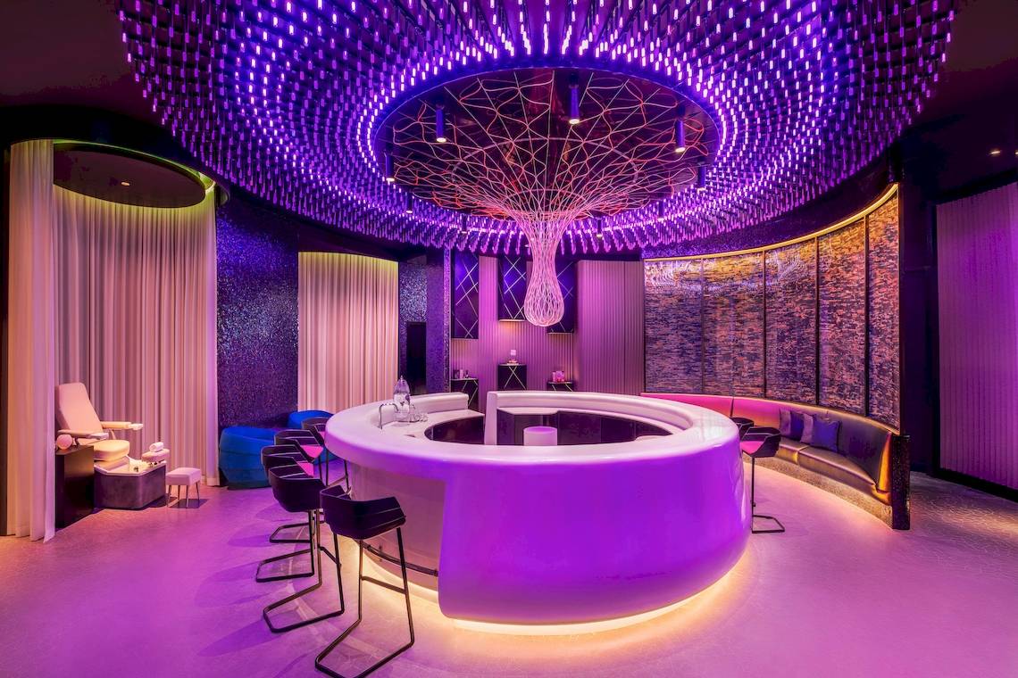 Innenansicht der Bar im W Dubai - The Palm mit lila Beleuchtung und Rundtheke.