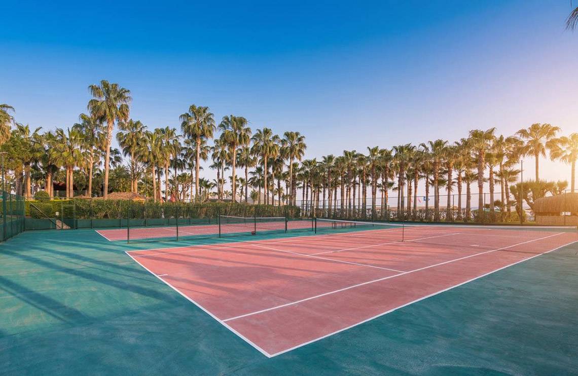 Tennisplätze des Miramare Queen Hotels mit Palmen im Hintergrund.