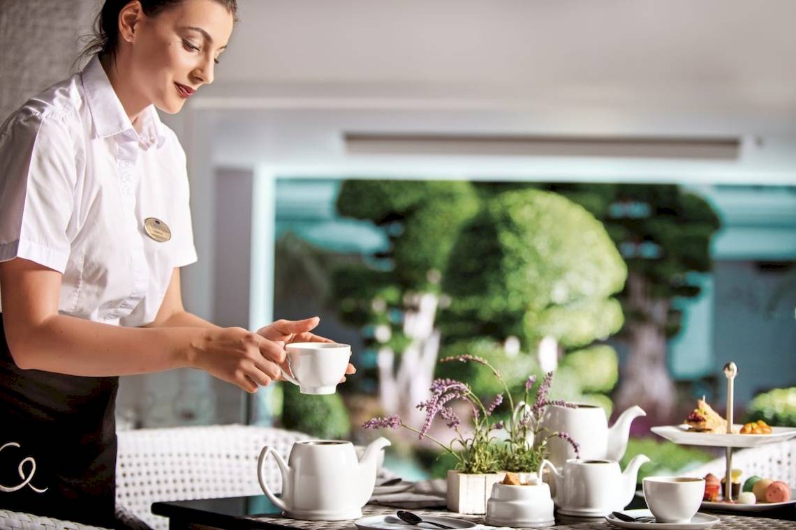 Frau beim Kaffee servieren im Mitsis Alila Resort & Spa