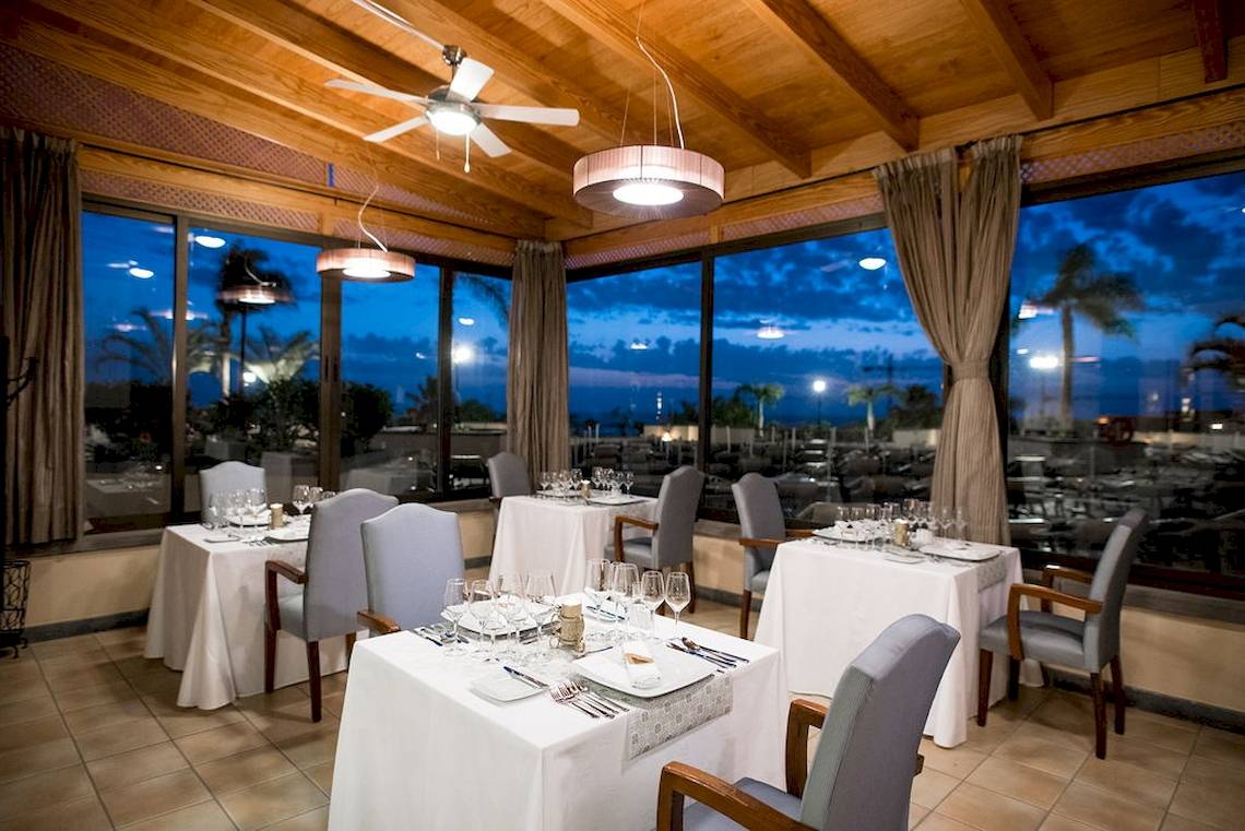 Innenansicht des Restaurants im GF Gran Costa Adeje Hotel mit großen Fenstern und Meerblick.
