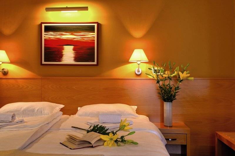 Doppelzimmer im Saudade Hotel mit einem Bett, Blumen, und einer dekorierten Wand.