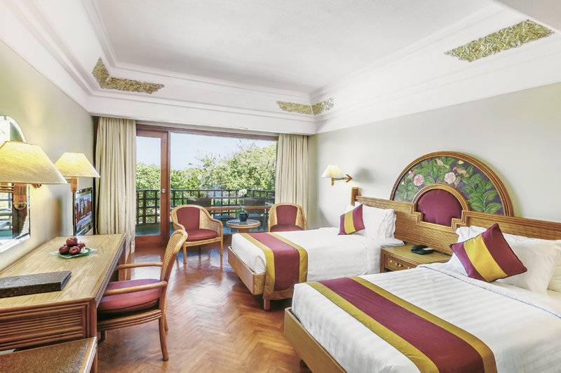 Doppelzimmer im Prama Sanur Beach Bali Hotel mit Balkon, zwei Betten und Schreibtisch.