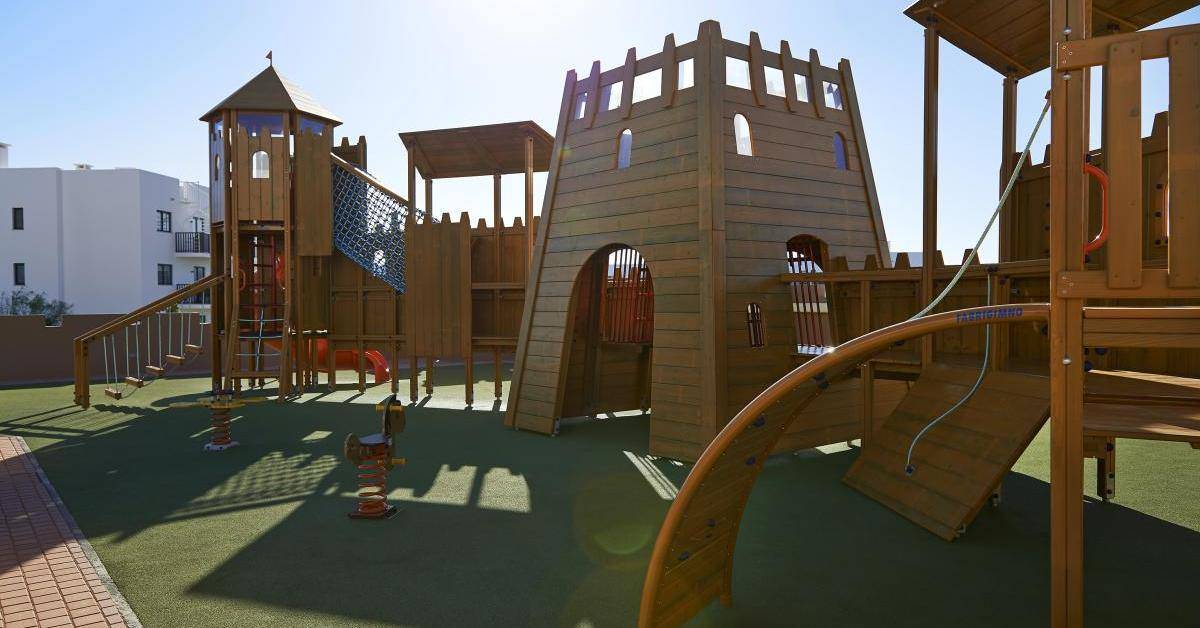 Kinderspielplatz im Melia Dunas Beach Resort & Spa mit Holzstrukturen und Rutschen.